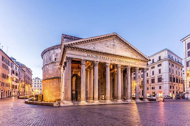 o Panteão de Roma, uma obra-prima da arquitetura romana. Construído inicialmente por Marco Vipsânio Agripa e reconstruído pelo imperador Adriano por volta de 126 d.C., o Panteão é famoso por sua grandiosa cúpula de concreto não reforçado e seu imponente pórtico com 16 colunas coríntias de granito. A inscrição no frontão, "M·AGRIPPA·L·F·COS·TERTIUM·FECIT", atribui a construção original a Agripa. Este monumento destaca-se por sua perfeita harmonia de proporções e sua preservação exemplar ao longo dos séculos.