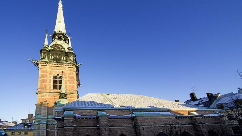 Igreja Alemã (Tyska Kyrkan) em Estocolmo, Suécia, localizada em Gamla Stan. Construída no século XVI, sua arquitetura gótica é destacada pela alta torre e detalhes em tijolo, simbolizando a herança da comunidade alemã na cidade.