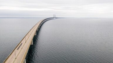 A Ponte de Øresund, uma maravilha da engenharia moderna, conecta a Dinamarca e a Suécia através do estreito de Øresund. A ponte, com seus pilares imponentes e vãos elegantes, transporta veículos e trens, facilitando o comércio e a viagem entre os dois países. Uma obra-prima que demonstra a capacidade humana de superar desafios geográficos e unir nações.