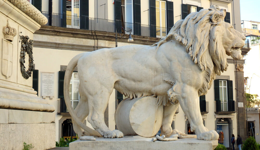 Escultura de um leão na base do monumento da Piazza dei Martiri, em Nápoles, simbolizando uma das fases das lutas pela independência italiana. Feita em mármore, a obra combina força e simbolismo histórico em um dos pontos mais icônicos da cidade.