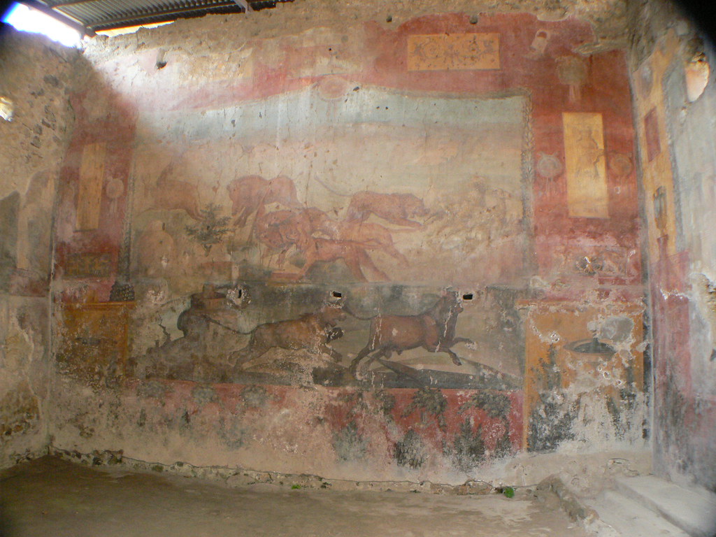 Detalhe de um afresco romano em Pompeia, retratando cenas com cavalos e paisagens, preservado nas paredes de uma estrutura antiga.